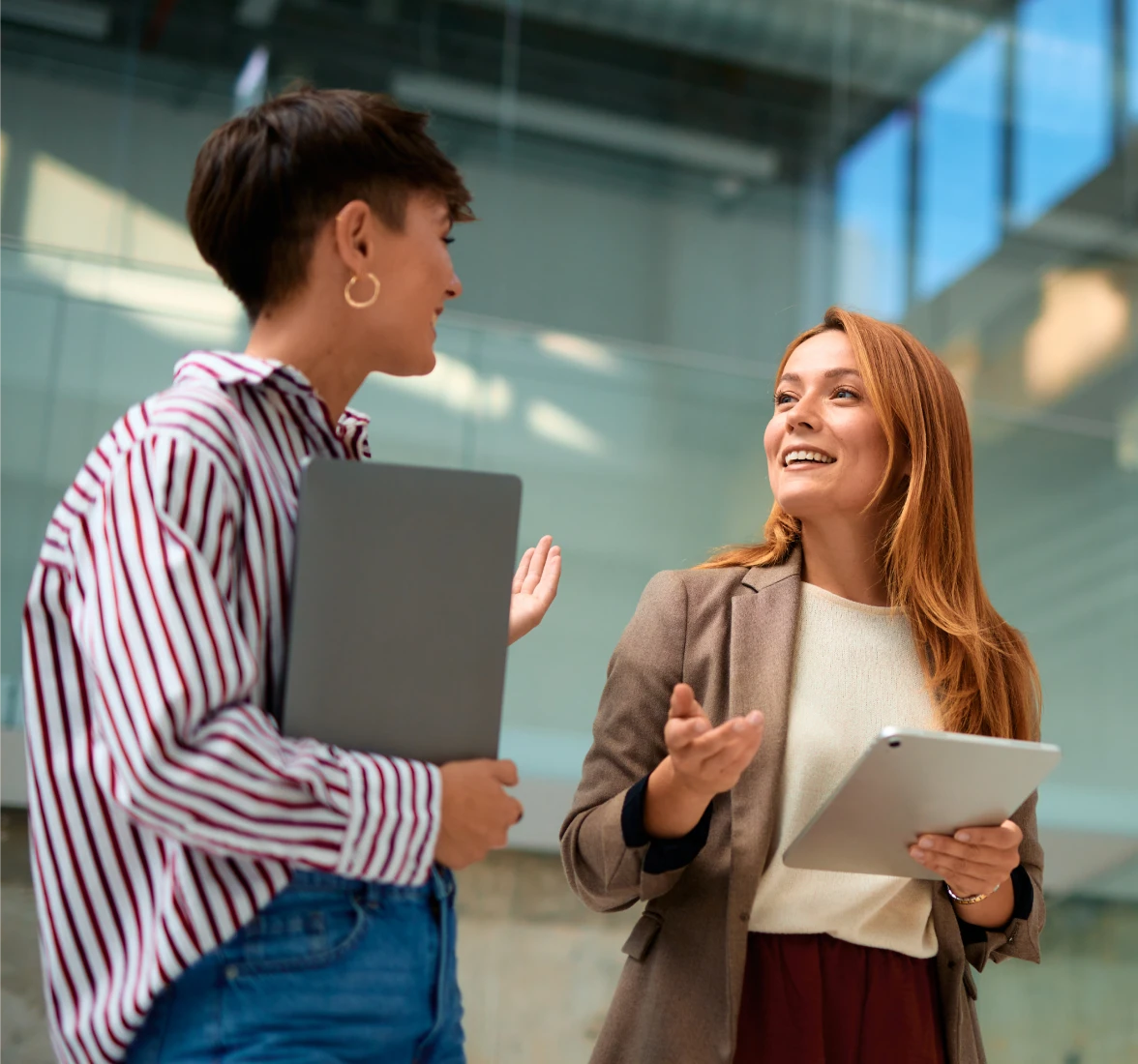 Two women talking with tablets
